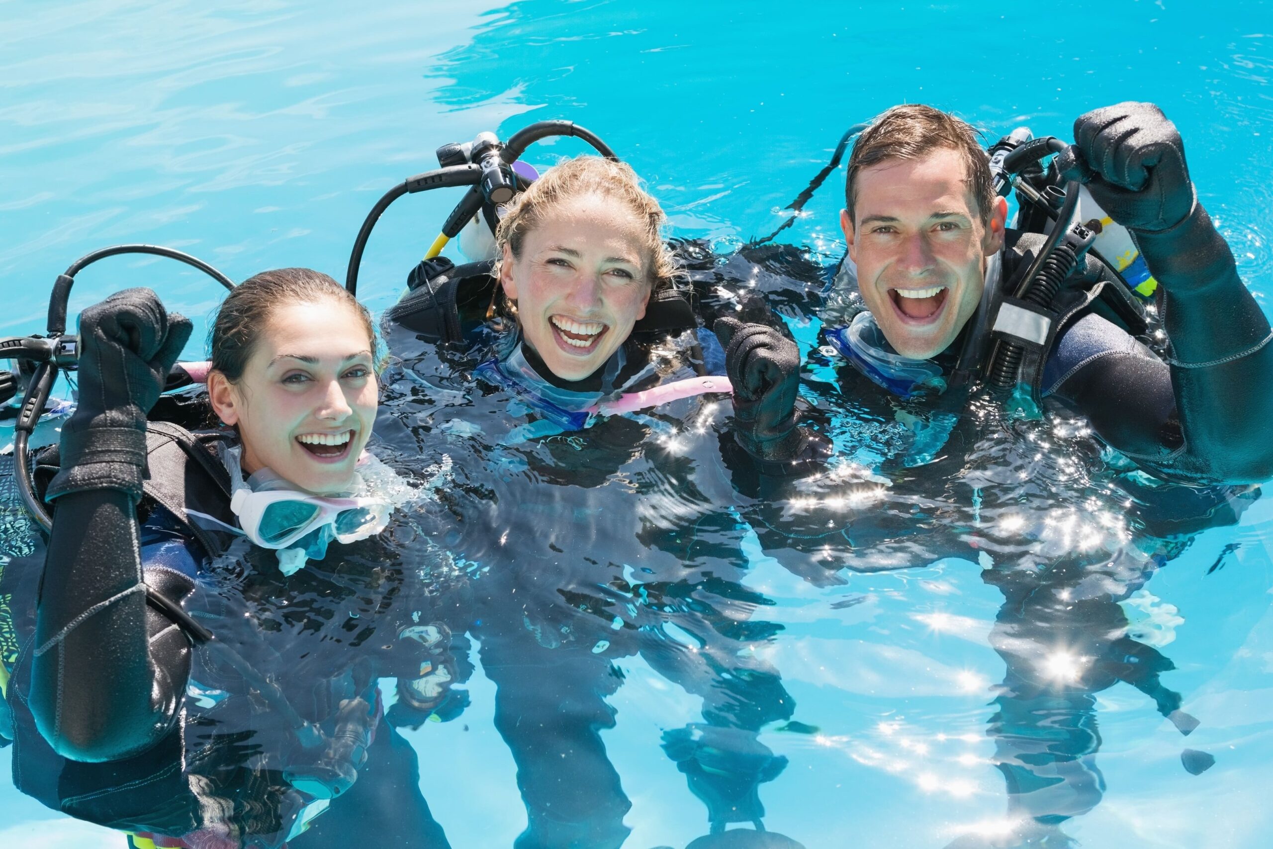 three people in scuba gear in a pool