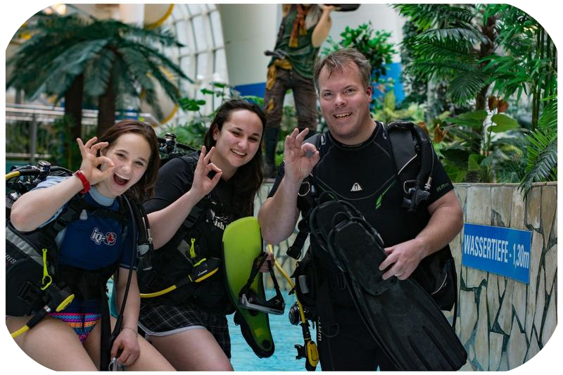 a group of people standing around a pool