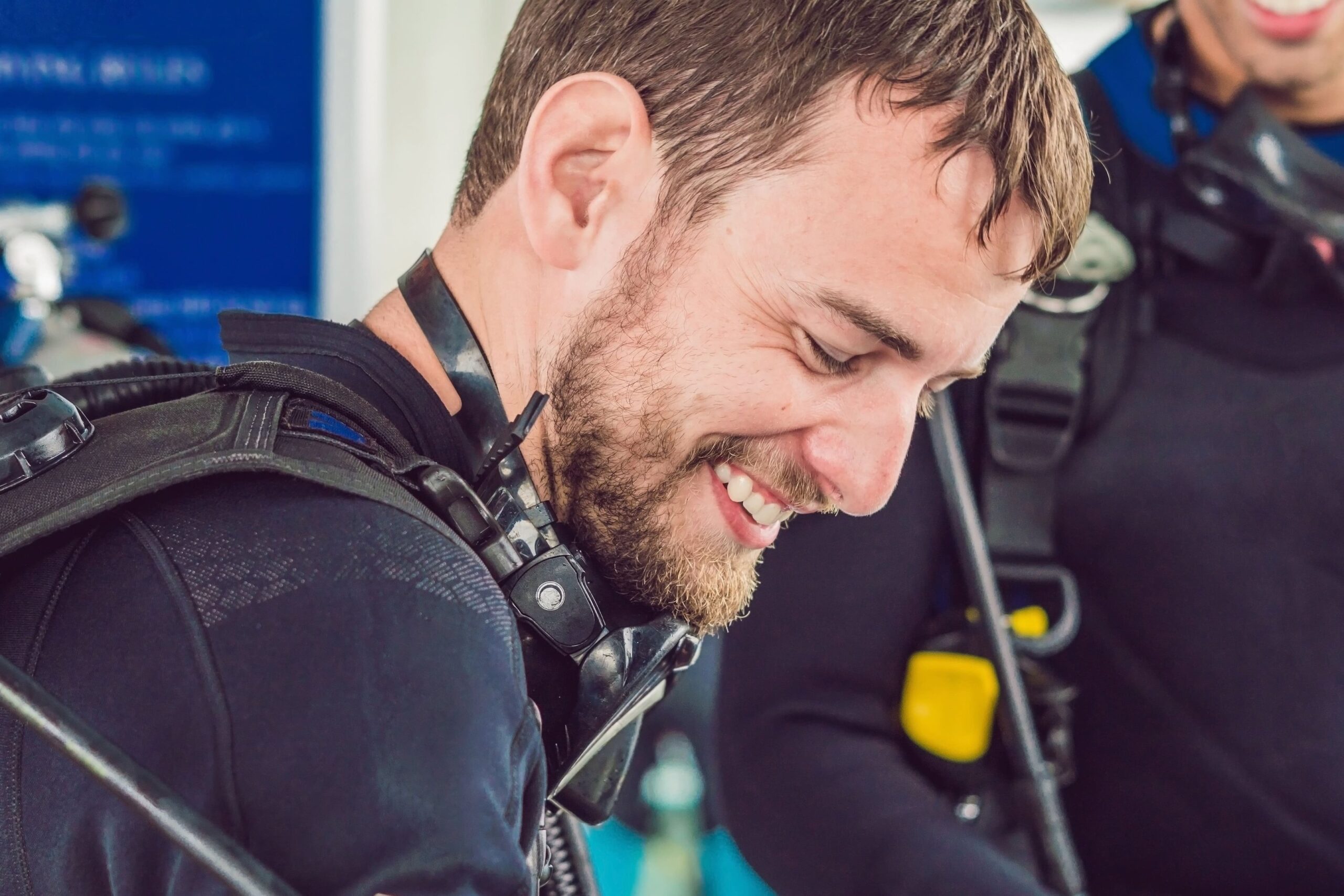 a man in a scuba suit is smiling and holding a cell phone
